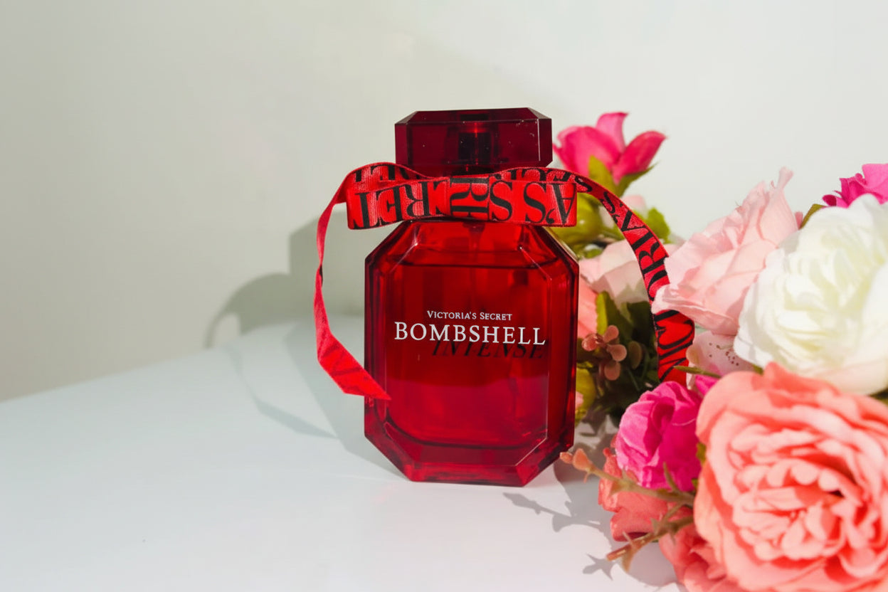 Red 'Victoria's Secret Bombshell' perfume bottle with floral background
