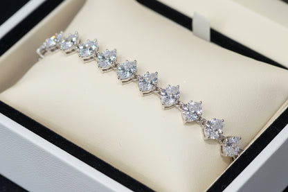 Silver bracelet with heart-shaped crystals on a dark surface