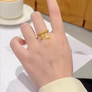 Gold ring with charms on a hand, blurred background