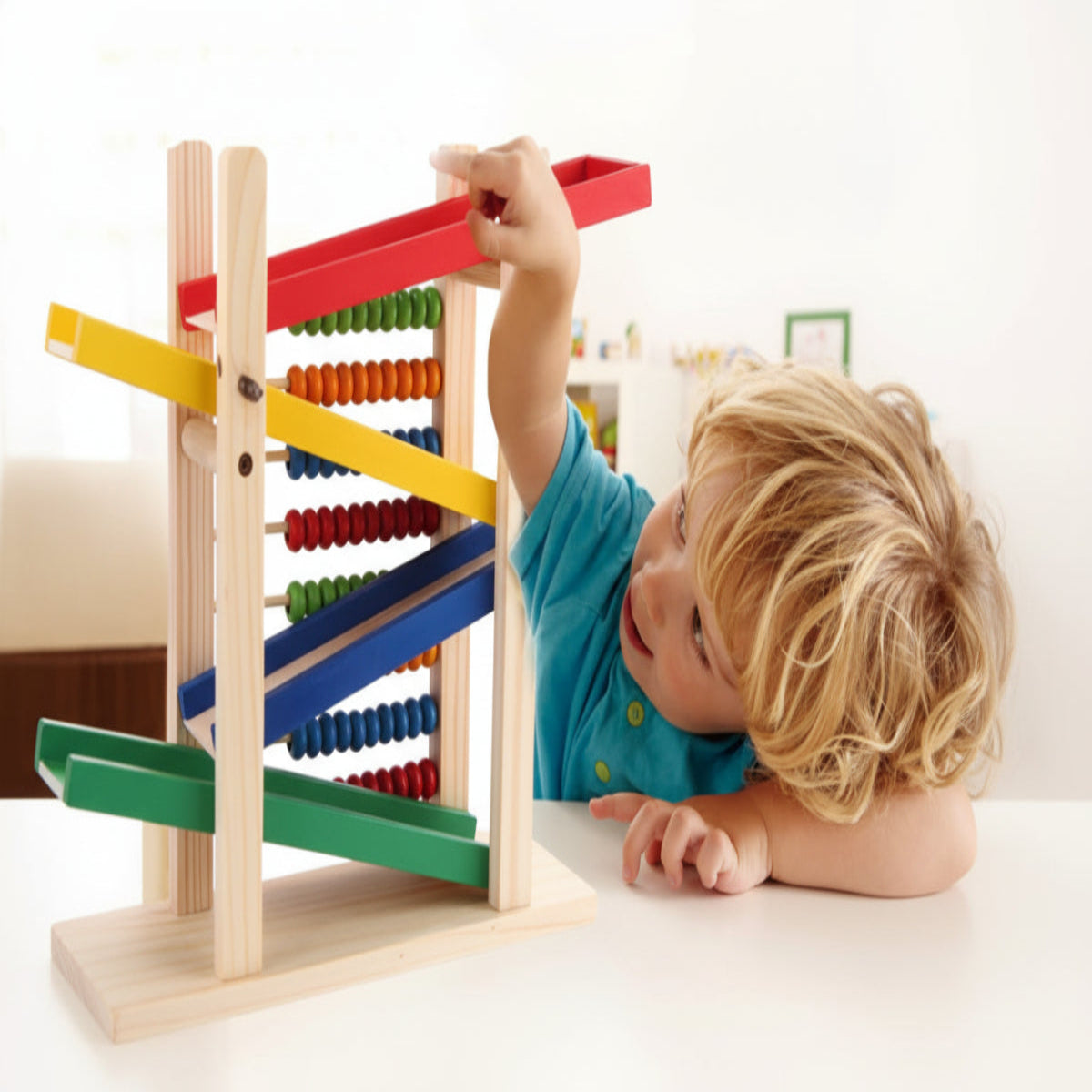 Child playing with a colorful wooden abacus on a white background