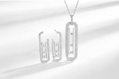 Silver necklace and earrings set on a white background