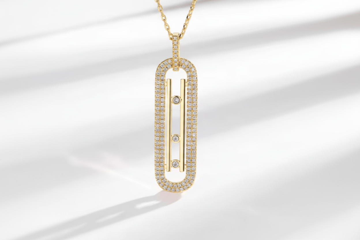 Gold necklace with a rectangular pendant on a light background