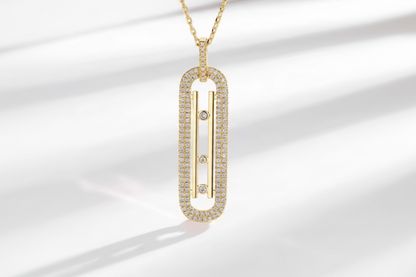 Gold necklace with a rectangular pendant on a light background